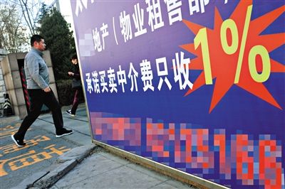 2014年3月20日，一小区门口贴着房产中介的宣传广告。新京报资料图片/记者 浦峰 摄