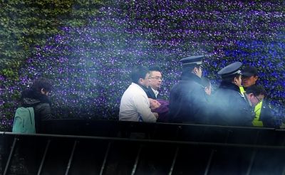 一位家属在现场晕倒，被民警和医护人员有序抬离陈毅广场 摄/法制晚报记者 吴海浪