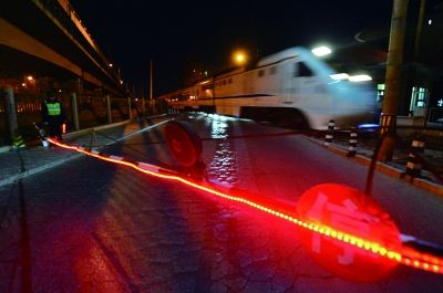 每当有火车经过，该路口就会放下栏杆拦住行人。但因此处地理位置加上人流车辆较多，仍存在安全隐患 摄/法制晚报记者 刘畅