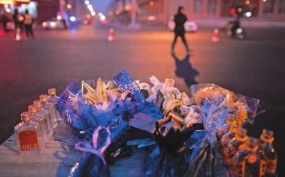 哈尔滨街头，市民自发摆上鲜花和酒水，悼念五位遇难的消防战士 新文化特派哈尔滨记者 郭亮 摄 