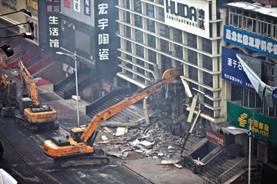 一台破拆机器正在现场进行破拆工作。1月2日，哈尔滨一仓库大火，5名消防员在救火中牺牲。本版摄影/新京报记者 周岗峰